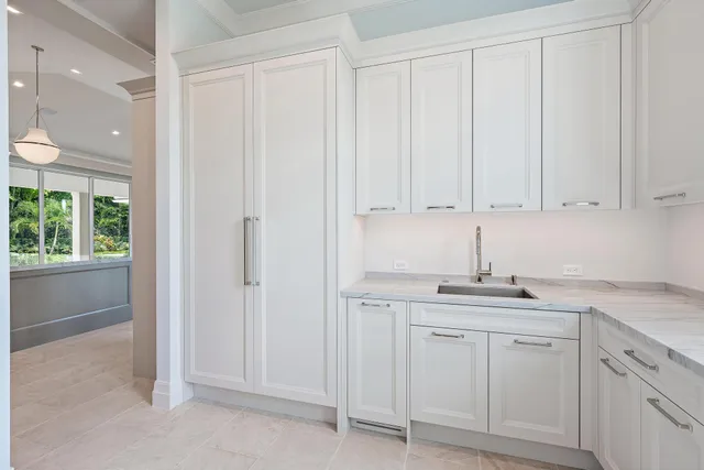a kitchen with white cabinets and sink