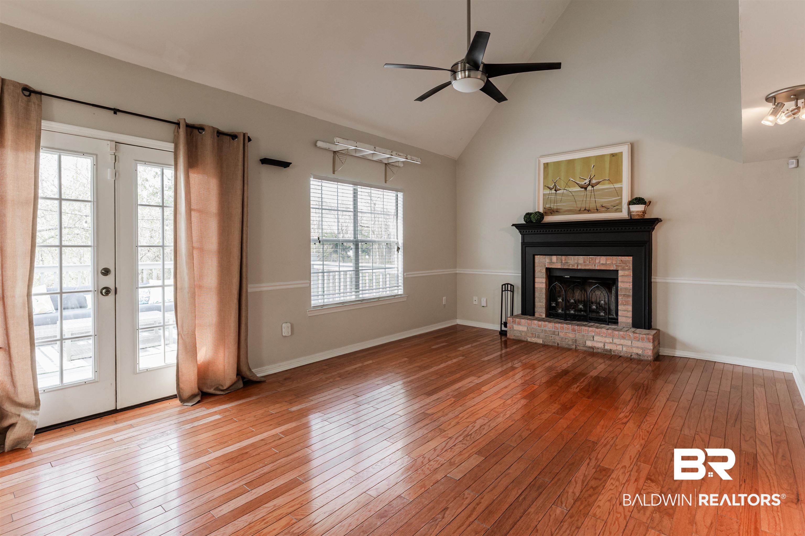 3844 Isabel Way South Mobile, AL 36693 - Photo 19 of 49 Unfurnished living room with hardwood / wood-style flooring, ceiling fan, high vaulted ceiling, a brick fireplace, and french doors
