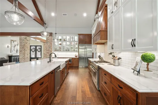 a large kitchen with a large counter top a sink a stove and a wooden floors