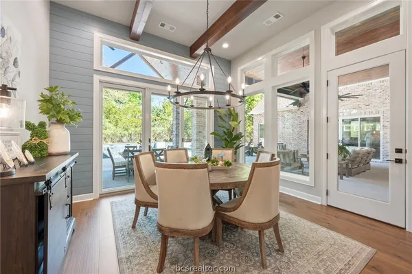 a dining room with furniture a chandelier and wooden floor