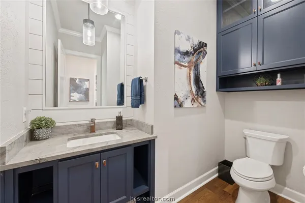 a bathroom with a granite countertop sink a toilet and mirror
