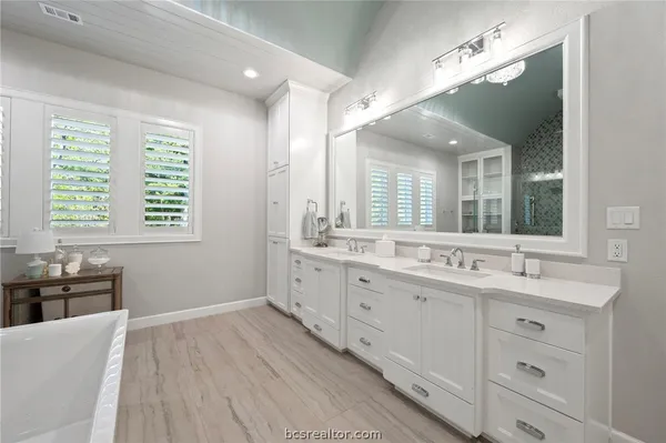 a bathroom with a double vanity sink and a mirror