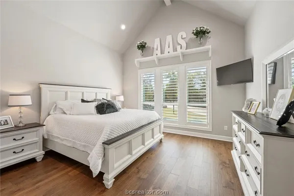 a bedroom with a bed and a flat tv screen on the dresser