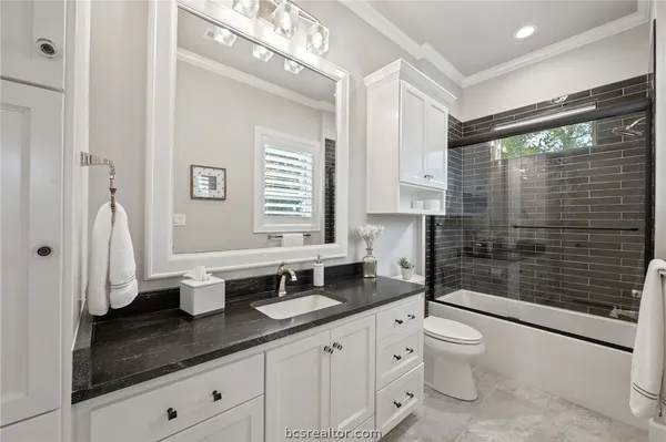 a bathroom with a double vanity sink toilet and shower