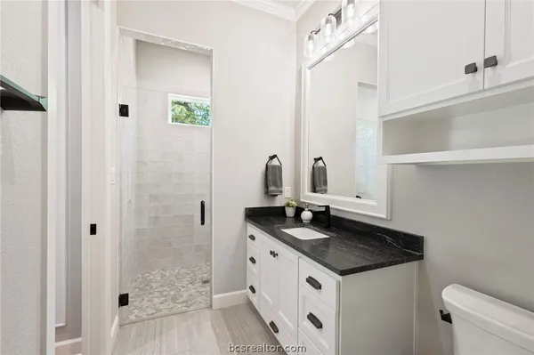 a bathroom with a granite countertop sink and a mirror
