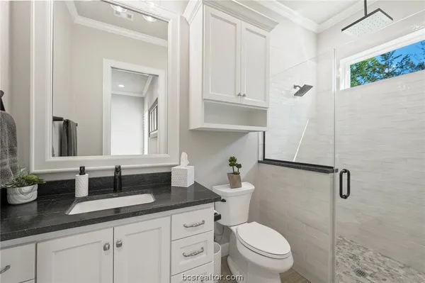 a bathroom with a granite countertop sink a toilet and a mirror