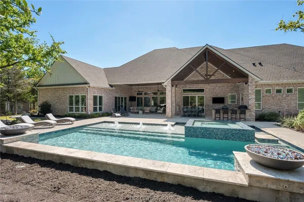 a view of a house with swimming pool and sitting area