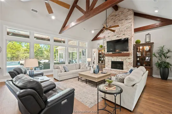 a living room with furniture a fireplace and a flat screen tv