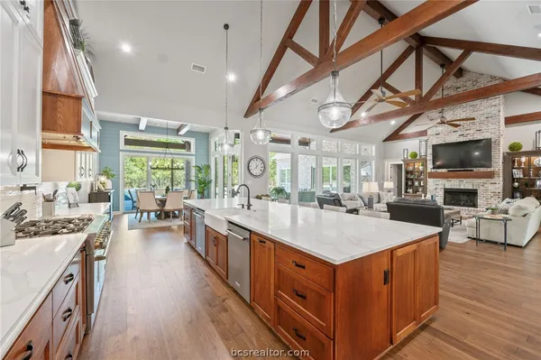 a large kitchen with stainless steel appliances granite countertop plenty wooden cabinets and wooden floor