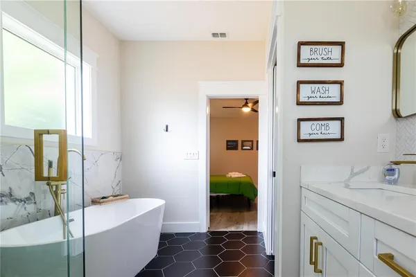 a bathroom with a tub sink and mirror