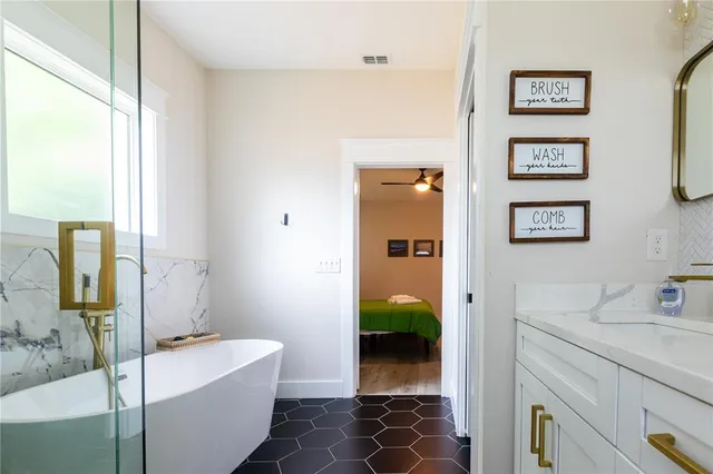 a bathroom with a tub sink and mirror