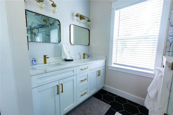 a bathroom with a double vanity sink and a window