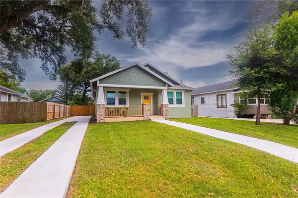 a front view of a house with a yard and trees
