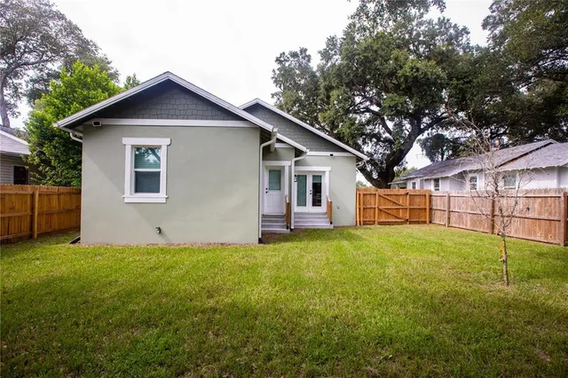 a view of a yard in front of a house with large trees