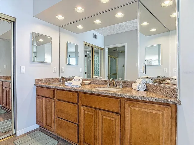 a bathroom with a granite countertop sink double and mirror