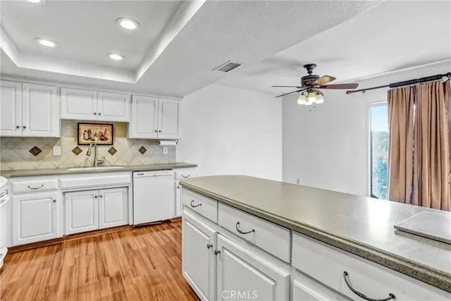 a kitchen with granite countertop white cabinets and white appliances