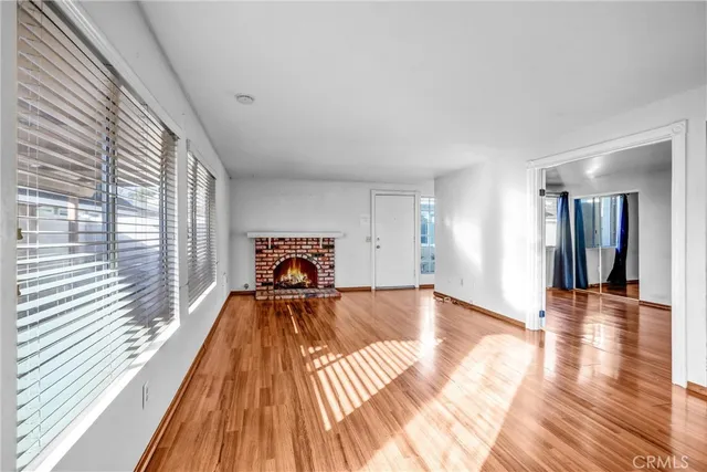 a view of a living room with a bed and wooden floor