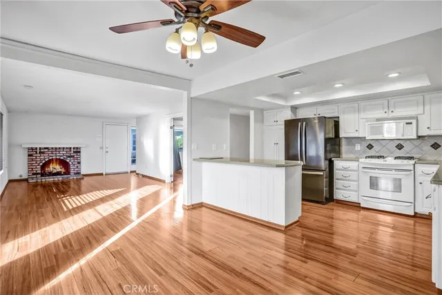 a kitchen with stainless steel appliances kitchen island granite countertop a refrigerator and a stove top oven