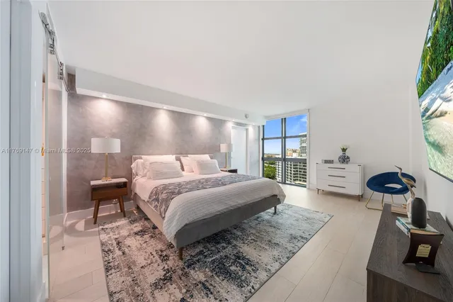 a spacious bedroom with a bed and a large window