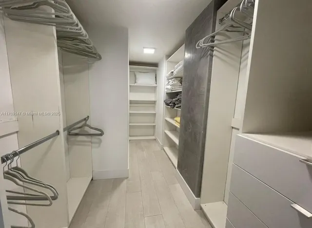 a view of walk in closet with empty racks