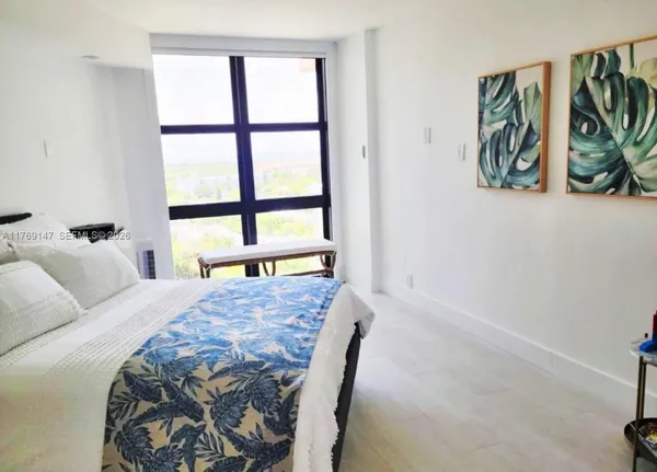 a spacious bedroom with a bed and a window