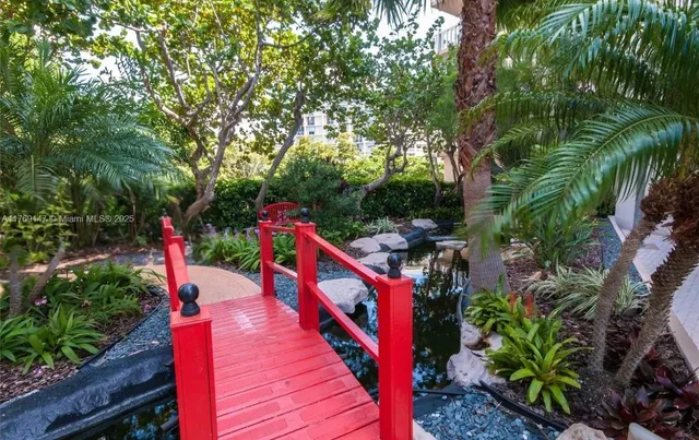 a view of a table and chairs under an umbrella in patio with wooden fence