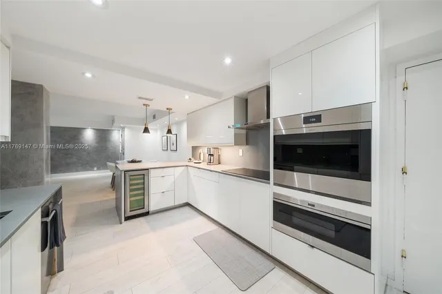 a large white kitchen with stainless steel appliances and white cabinets