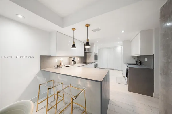 a kitchen with a sink a stove and chairs