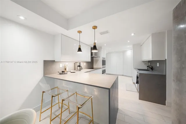 a kitchen with a sink a stove and chairs