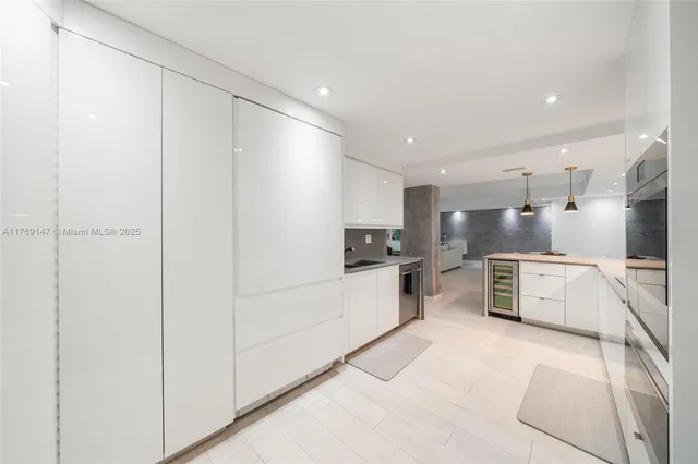 a large white kitchen with cabinets