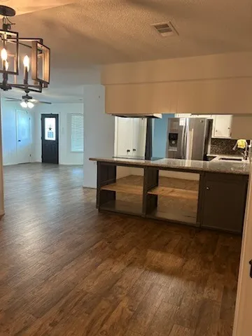 a kitchen with stainless steel appliances wooden floor and a refrigerator