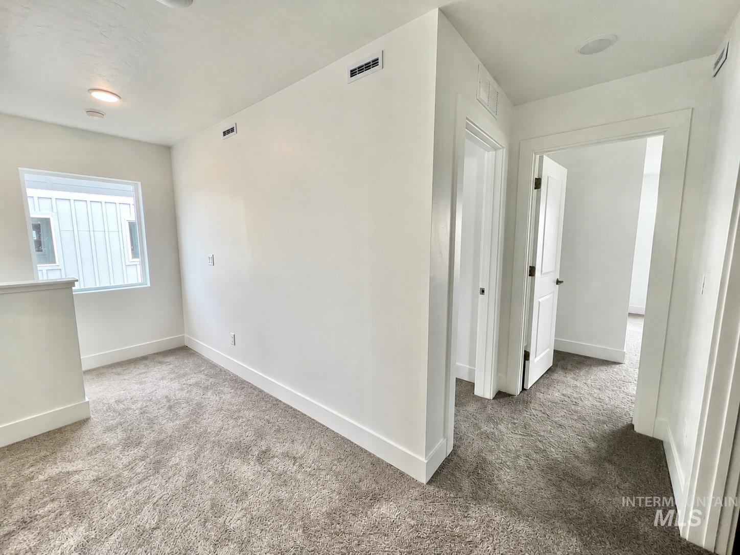 8098 West Fern Street Eagle, ID 83616 - Photo 10 of 22 Expansive hallway with neutral-toned carpeting and bright white walls