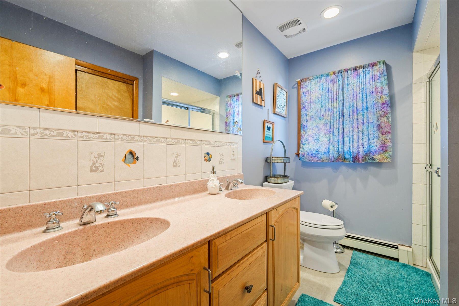 214 Pipe Stave Hollow Road Mount Sinai, NY 11766 - Photo 12 of 25 a bathroom with a sink double vanity and a mirror