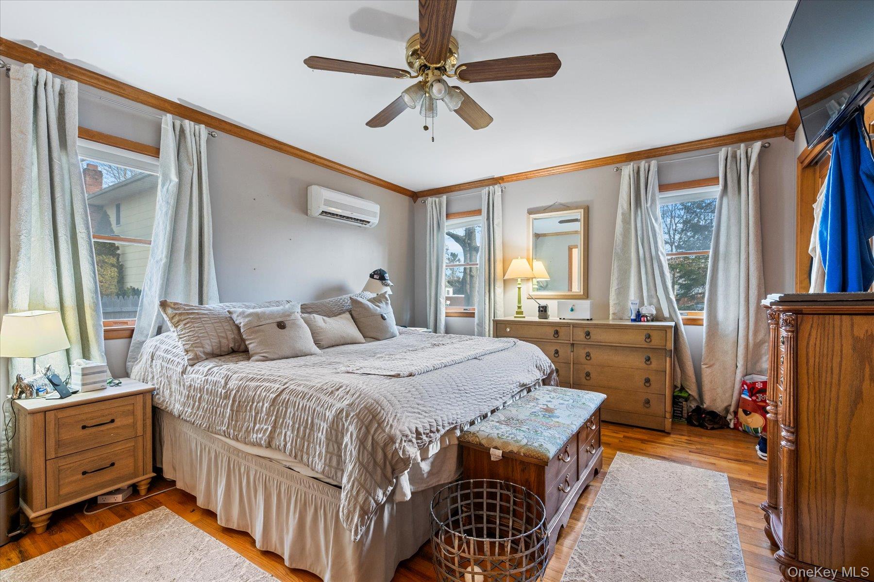 214 Pipe Stave Hollow Road Mount Sinai, NY 11766 - Photo 15 of 25 a bedroom with a bed and a chandelier