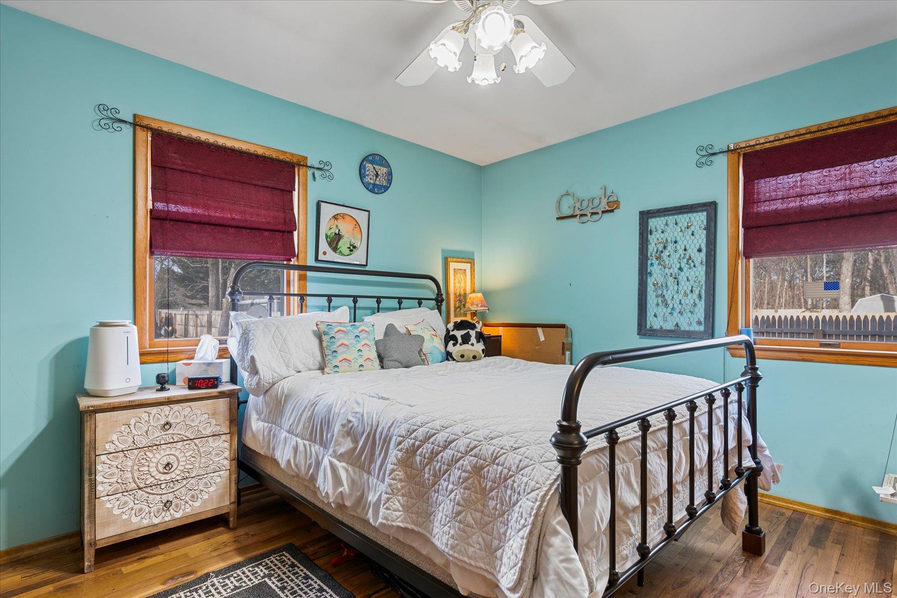 214 Pipe Stave Hollow Road Mount Sinai, NY 11766 - Photo 18 of 25 a bedroom with a bed and wooden floor