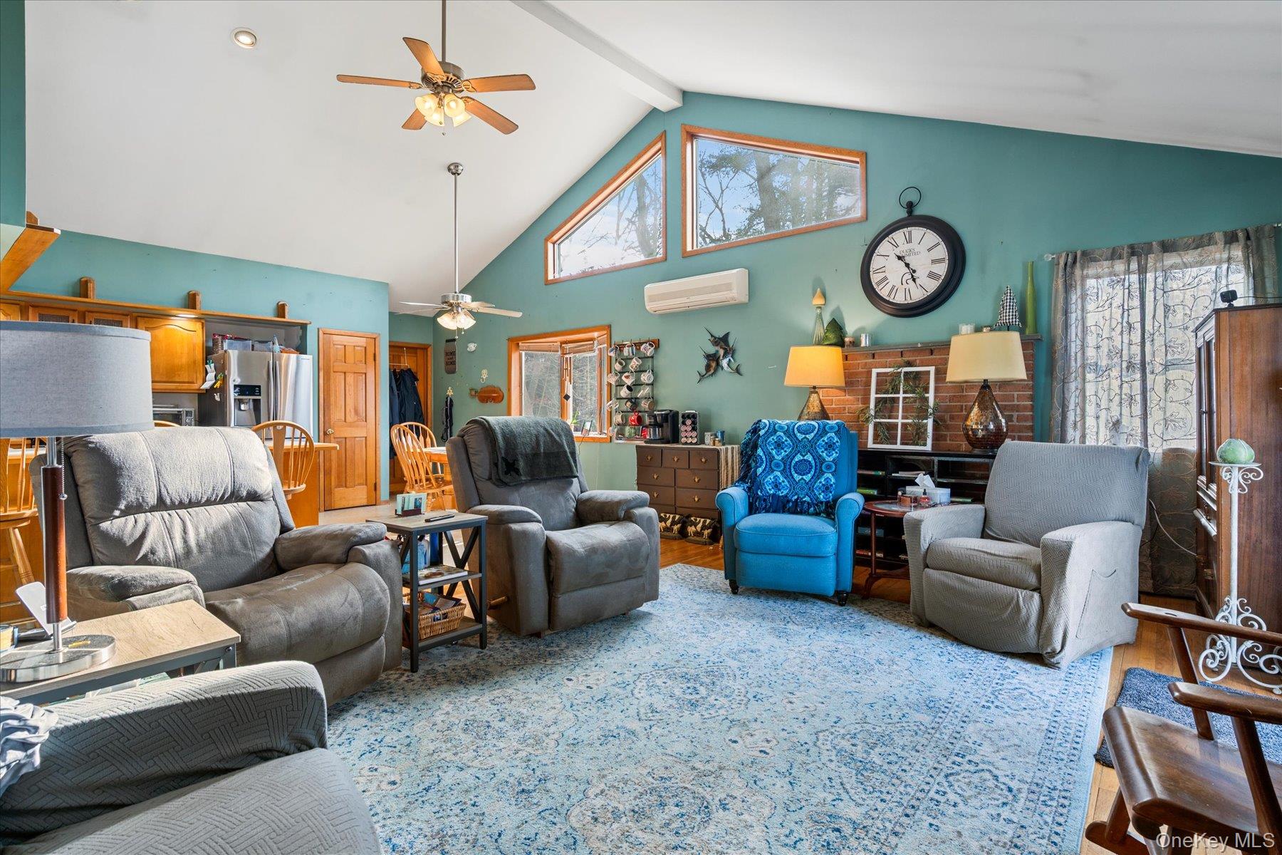 214 Pipe Stave Hollow Road Mount Sinai, NY 11766 - Photo 8 of 25 a living room with furniture a clock and a ceiling fan