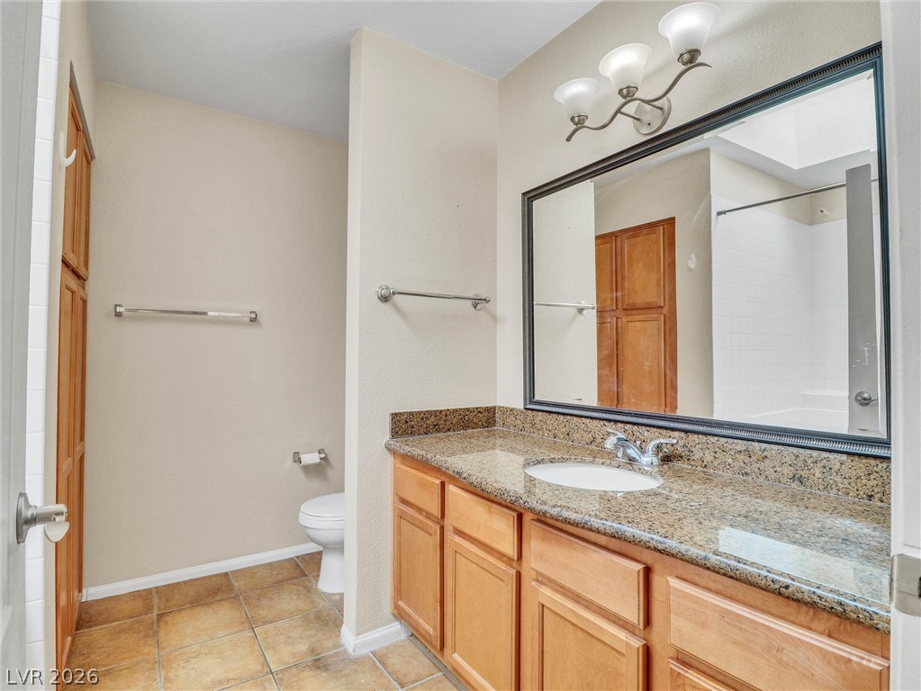 3145 East Flamingo Road, Unit 2129 Las Vegas, NV 89121 - Photo 18 of 43 A well-lit bathroom features a broad vanity with stone counters and a spacious mirror.