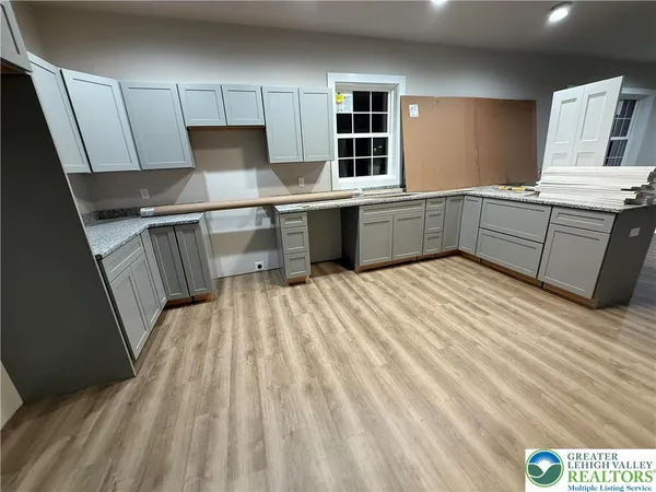 a kitchen with a sink a stove cabinets and a wooden floor