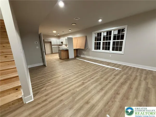 a view of a livingroom with wooden floor and staircase