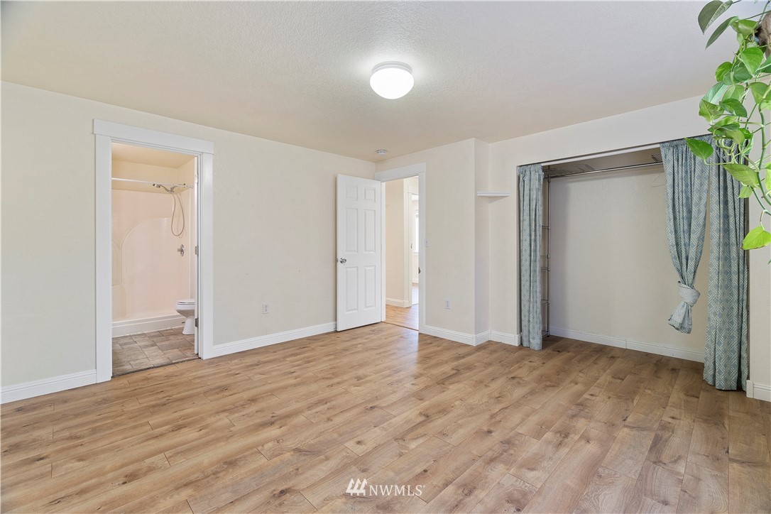 18135 Tamara Lane Southwest Rochester, WA 98579 - Photo 12 of 20 a view of an empty room with wooden floor and a window
