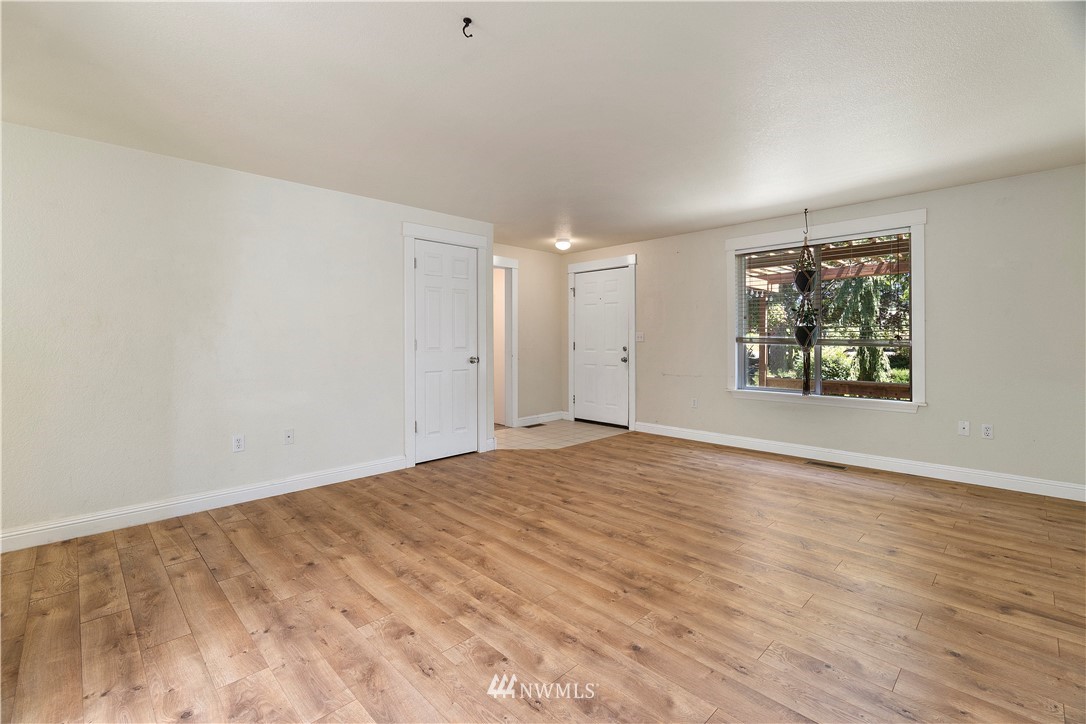 18135 Tamara Lane Southwest Rochester, WA 98579 - Photo 6 of 20 an empty room with wooden floor and windows