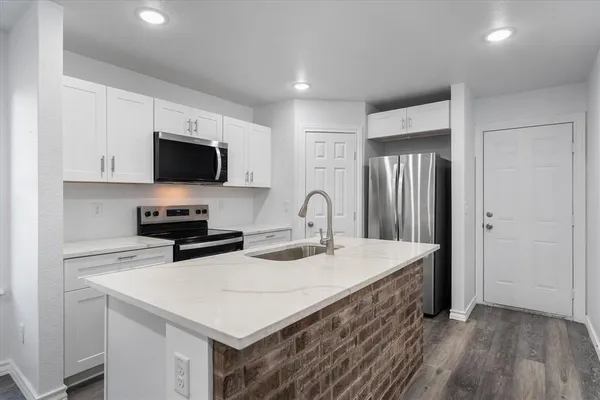 a kitchen with a sink a stove and a microwave