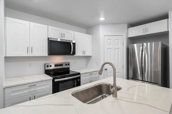a kitchen with a sink cabinets and appliances