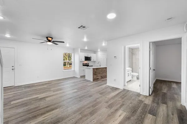 an empty room with a window and a ceiling fan