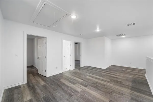 an empty room with wooden floor ceiling fan and windows