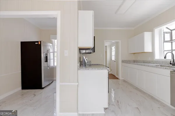a kitchen with granite countertop white cabinets and a sink