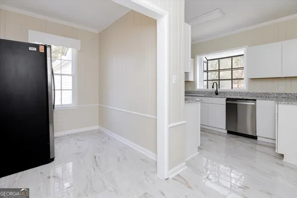 a kitchen with granite countertop a sink stainless steel appliances and cabinets