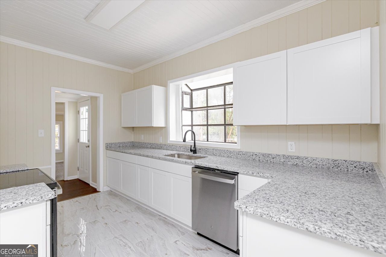 1205 Swift Street Perry, GA 31069 - Photo 21 of 63 a kitchen with granite countertop a sink and a stove