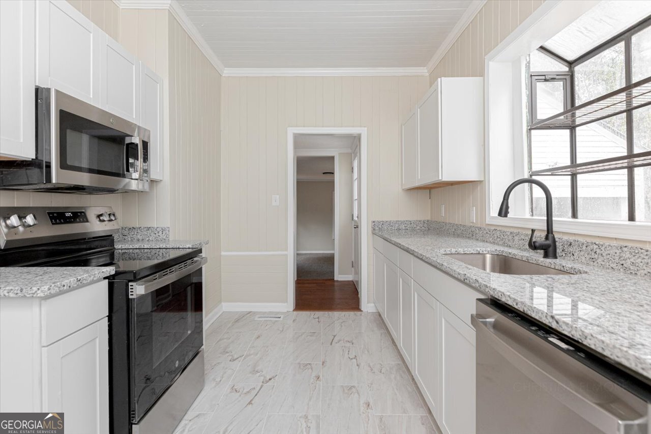 1205 Swift Street Perry, GA 31069 - Photo 22 of 63 a kitchen with granite countertop a sink stainless steel appliances and cabinets
