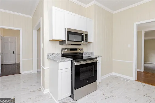 a kitchen with granite countertop white cabinets and sink